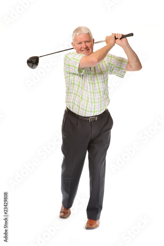 Happy casual mature golfer swinging a club