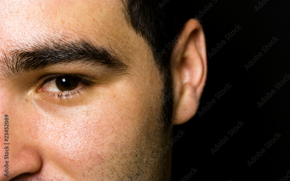 half of the face portrait of an young man on black background half of the face portrait of an young man on black background