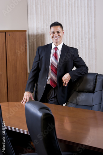 Happy mid-adult Hispanic businessman in boardroom