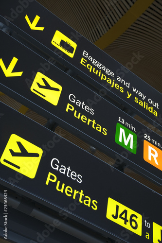 Airport departure gate sign written in English and Spanish