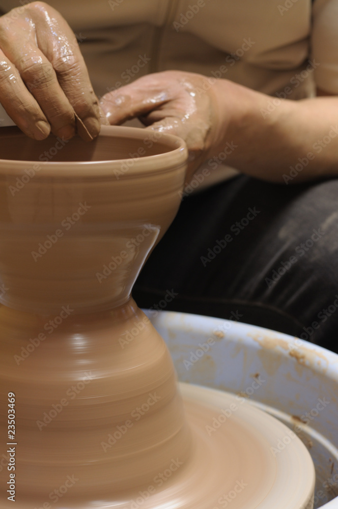 potter's wheel and hands of craftsman hold a jug potter's wheel and hands of craftsman hold a jug