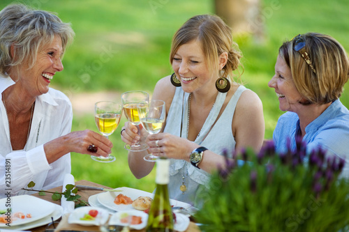 drei frauen trinken wei  wein im garten