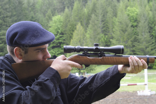 Man looking through scope on a rifle gun