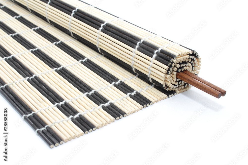 Obraz premium Half-rolled bamboo mat with chopsticks on white