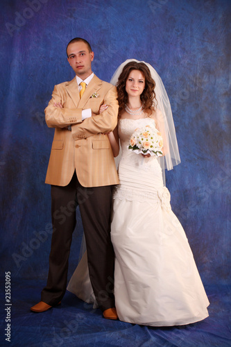Bride and groom over blue studio background