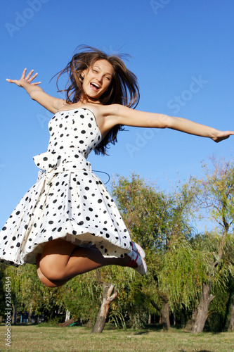Girl jumping against blue sky