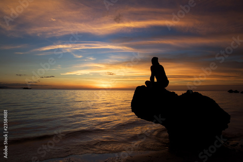 Man and beautiful sunset at tropical beach.