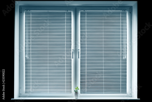 Window with blinds isolated on black.