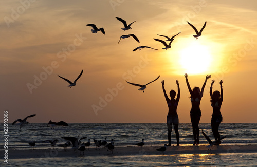 Canvas Print Three Young Women Dancing On Beach At Sunset