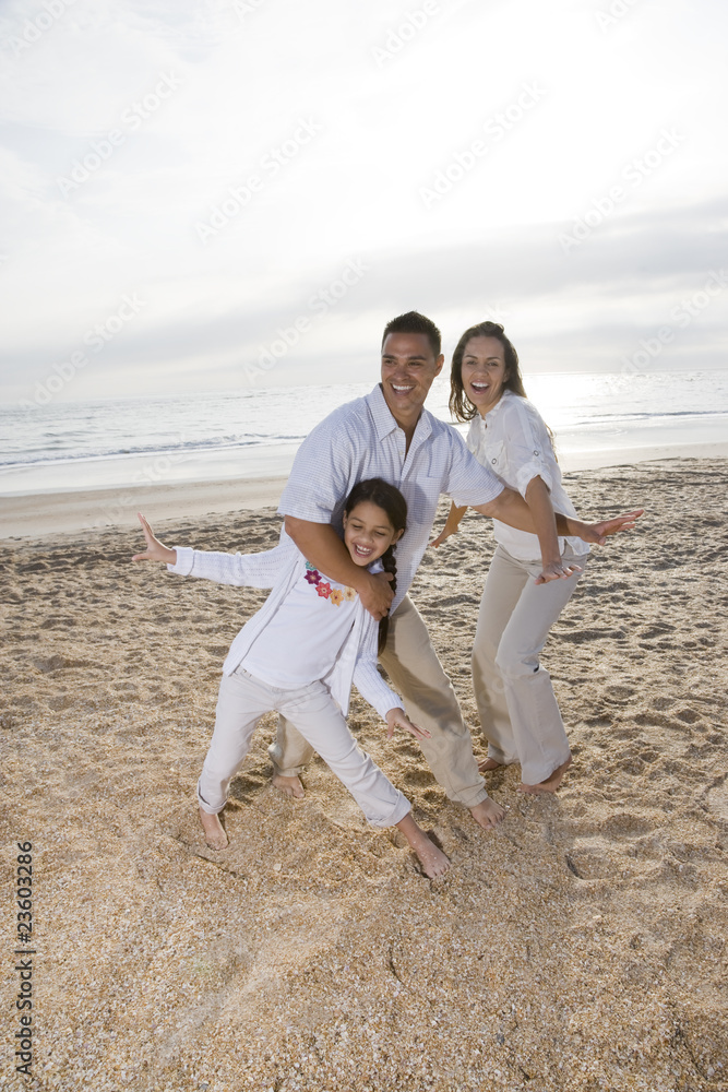 Hispanic family with girl having fun on beach Hispanic family with girl having fun on beach