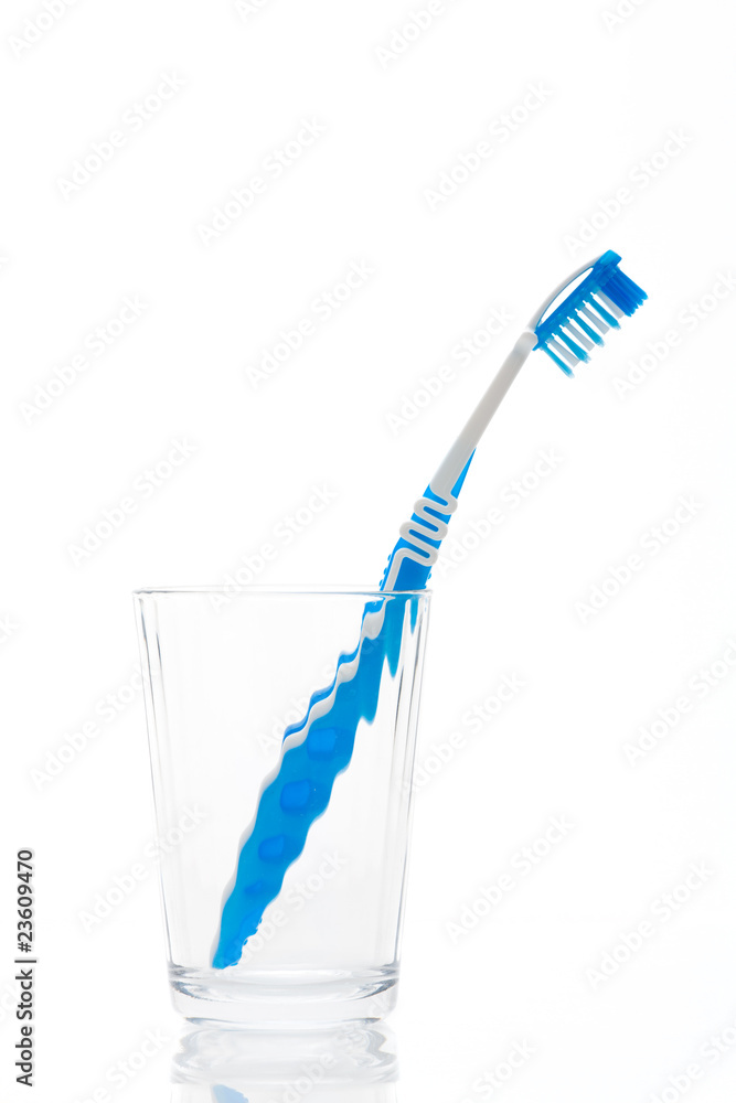 A blue toothbrush in glass isolated on a white background A blue toothbrush in glass isolated on a white background