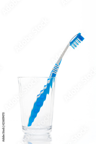 A blue toothbrush in glass isolated on a white background
