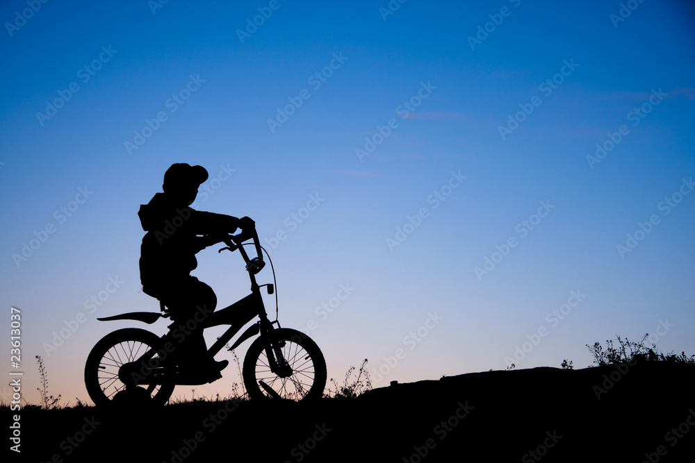 Fototapeta premium Silhouette of boy on bike