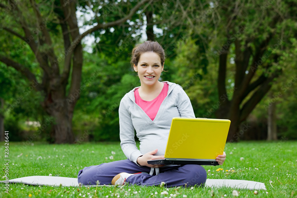Beautiful pregnant woman with laptop in the park Beautiful pregnant woman with laptop in the park
