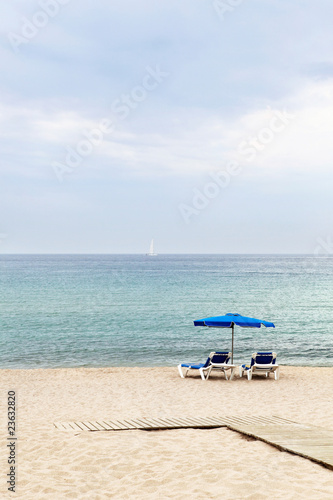 Two beach armchairs and umbrella