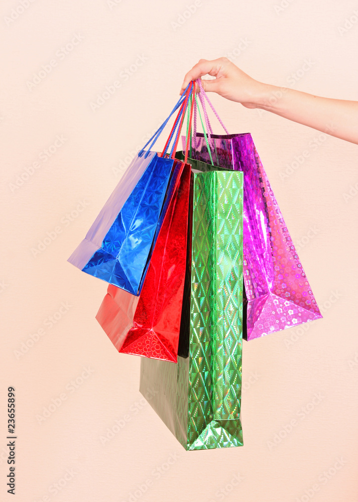 A woman hand  holding many  colorful shopping bags