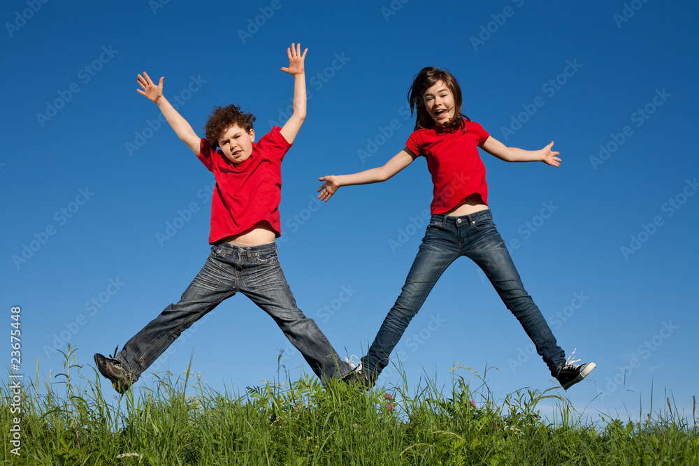 Girl and boy jumping, running against blue sky Girl and boy jumping, running against blue sky