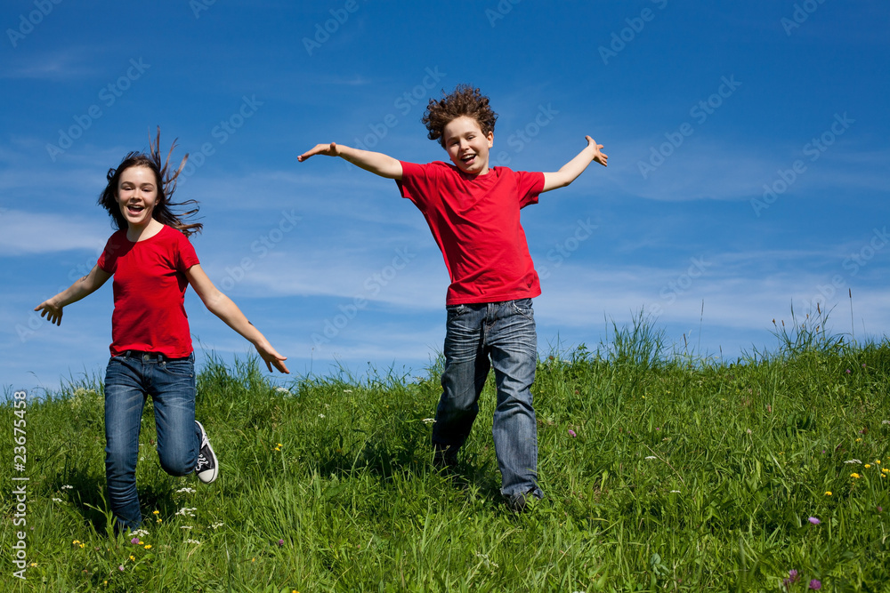 Girl and boy jumping, running against blue sky Girl and boy jumping, running against blue sky
