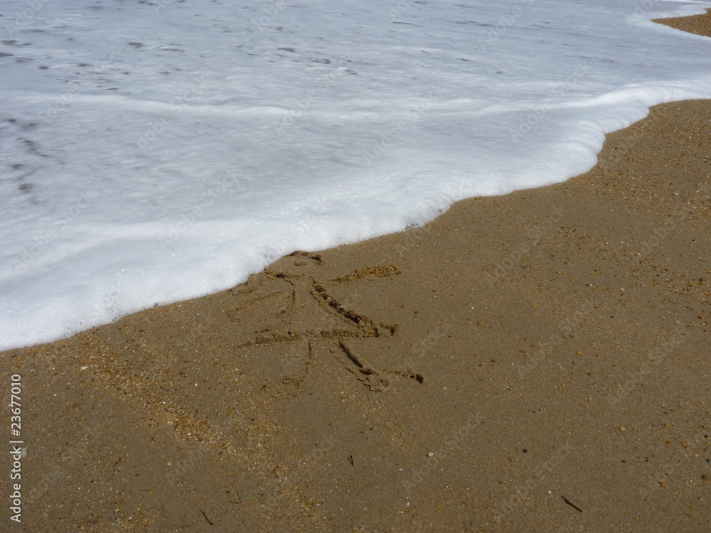 enfant dessiné sur le sable d'une plage enfant dessiné sur le sable d'une plage