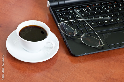 cup of coffee with a laptop and glasses