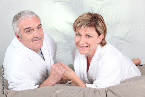 Couple de seniors allong  s en peignoir dans un lit