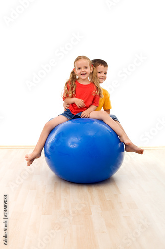 Kids having fun and exercises with a large ball