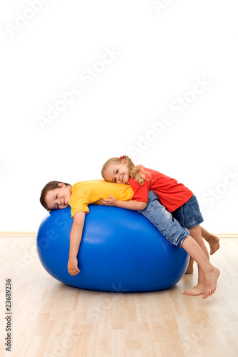 Kids having fun relaxing on a large rubber ball
