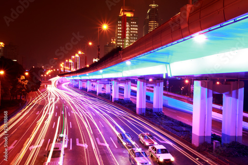 modern urban city at night with freeway traffic .