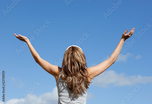 Blond woman relaxing against blue sky