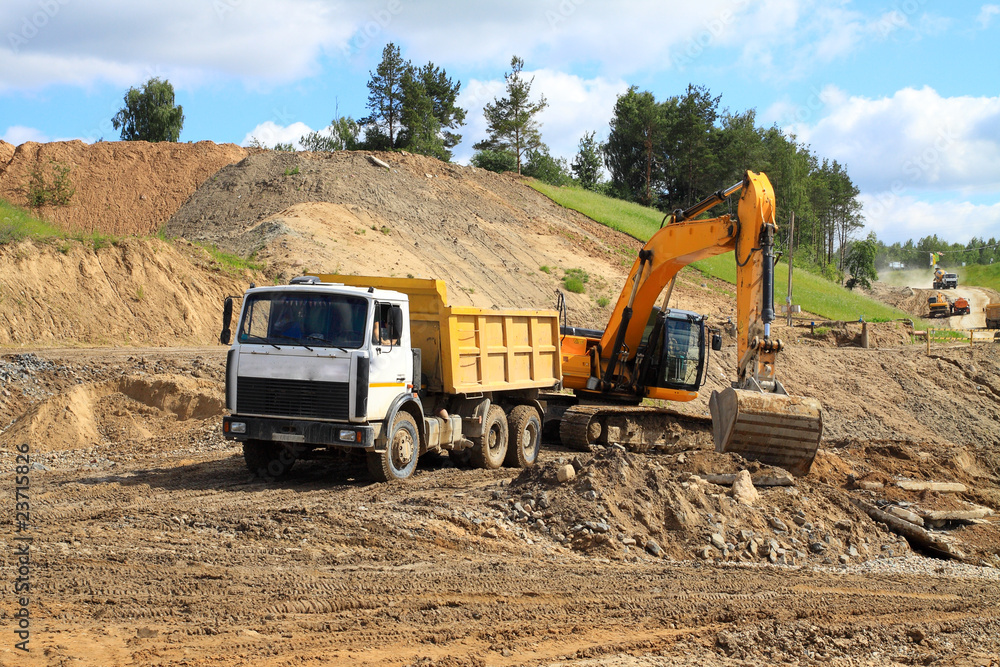 Fototapeta premium Backhoe loader loading dumper
