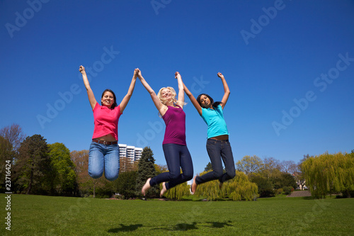 Drei Frauen springen im Park