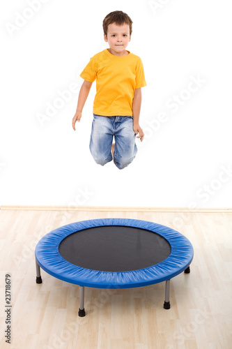 Boy jumping high on trampoline