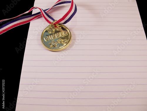 Golden medal with ribbon on note block photo