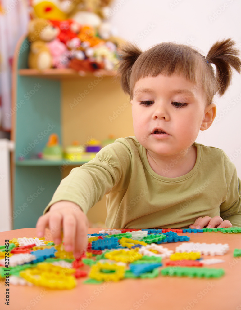Little girl play with building bricks in preschool Little girl play with building bricks in preschool