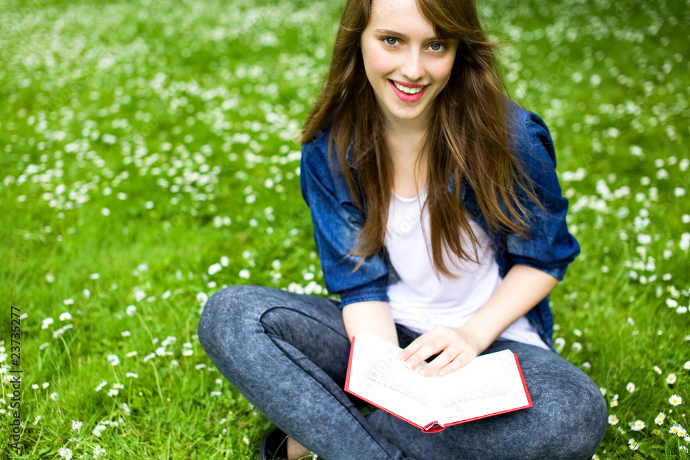 Young woman sitting with book on grass Young woman sitting with book on grass