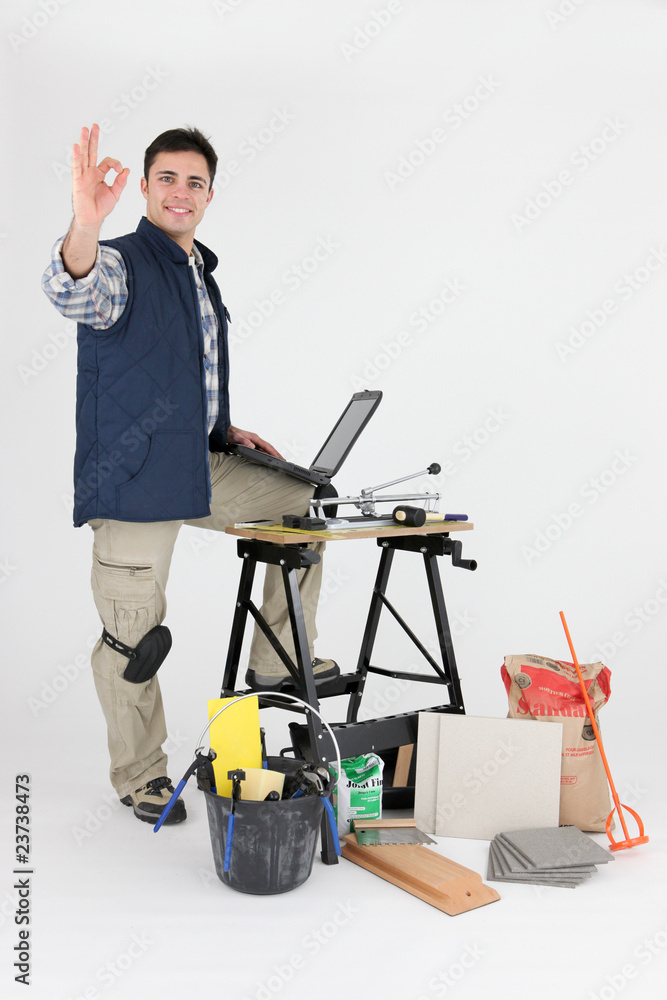 Carreleur ravi devant ordinateur portable Carreleur ravi devant ordinateur portable