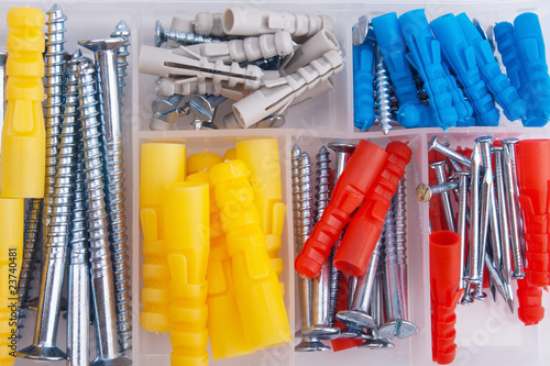 Screws and plugs in plastic toolbox, top view photo