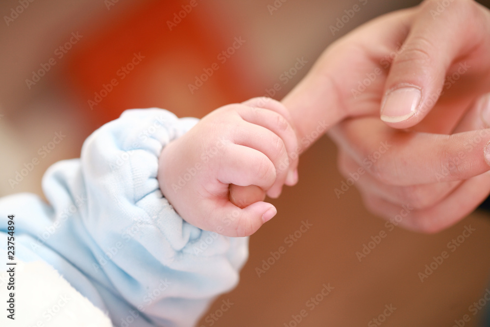 a baby holding his mother's big finger a baby holding his mother's big finger