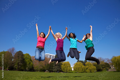 Vier Frauen springen im Park