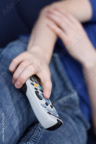 Guy watching tv with remote