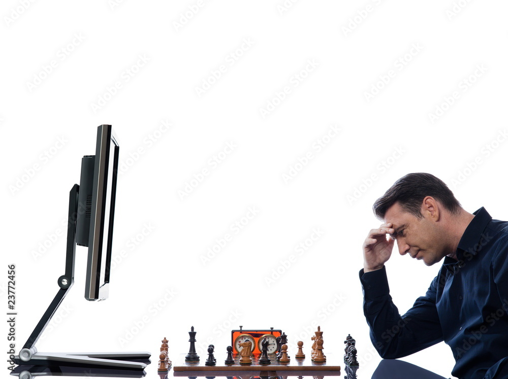 Man playing chess against computer Stock Photo