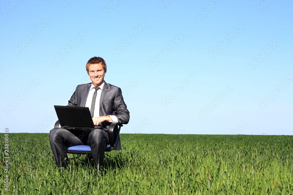 Happy businessman on field, with a laptop Happy businessman on field, with a laptop