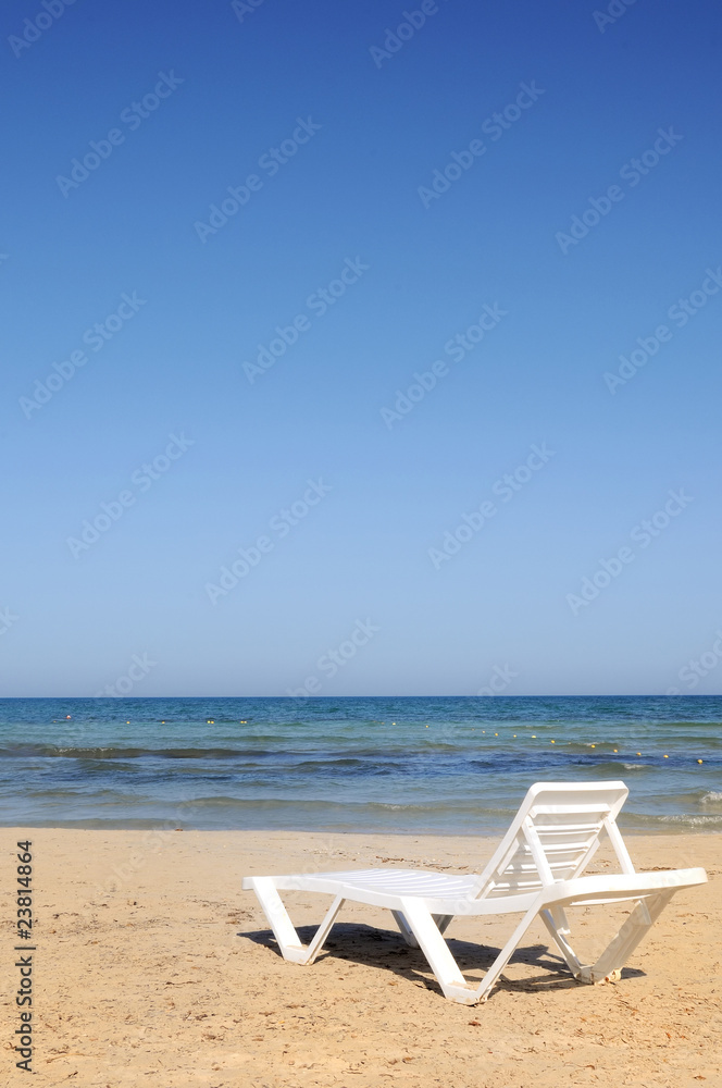 deckchairs on the beach under blue sky