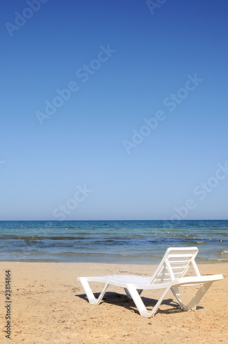 deckchairs on the beach under blue sky