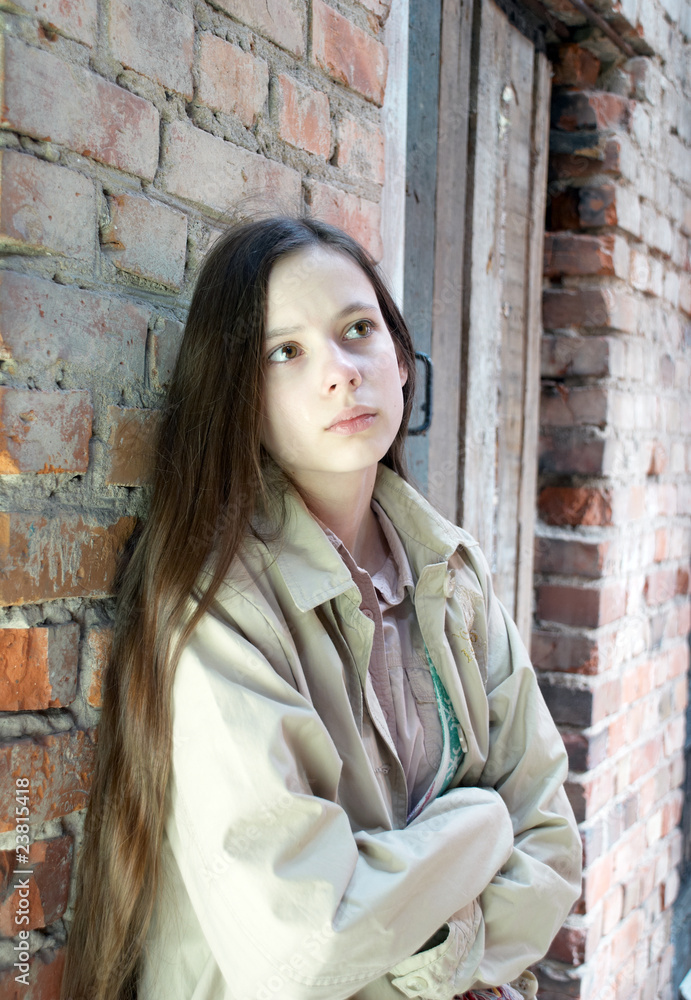 Upset girl near brick wall Upset girl near brick wall