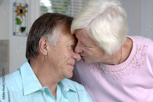 Senior couple shares tender moment in their kitchen.
