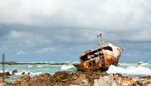 Rusting broken Shipwreck lying on the rocks photo