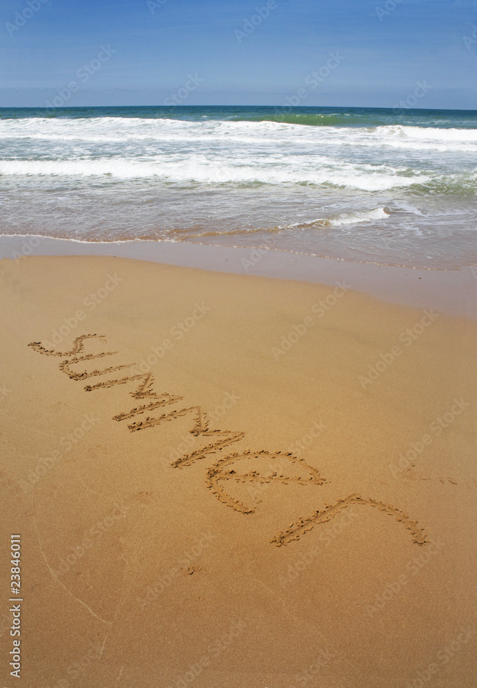 summer written in a sandy tropical beach and blue sky summer written in a sandy tropical beach and blue sky