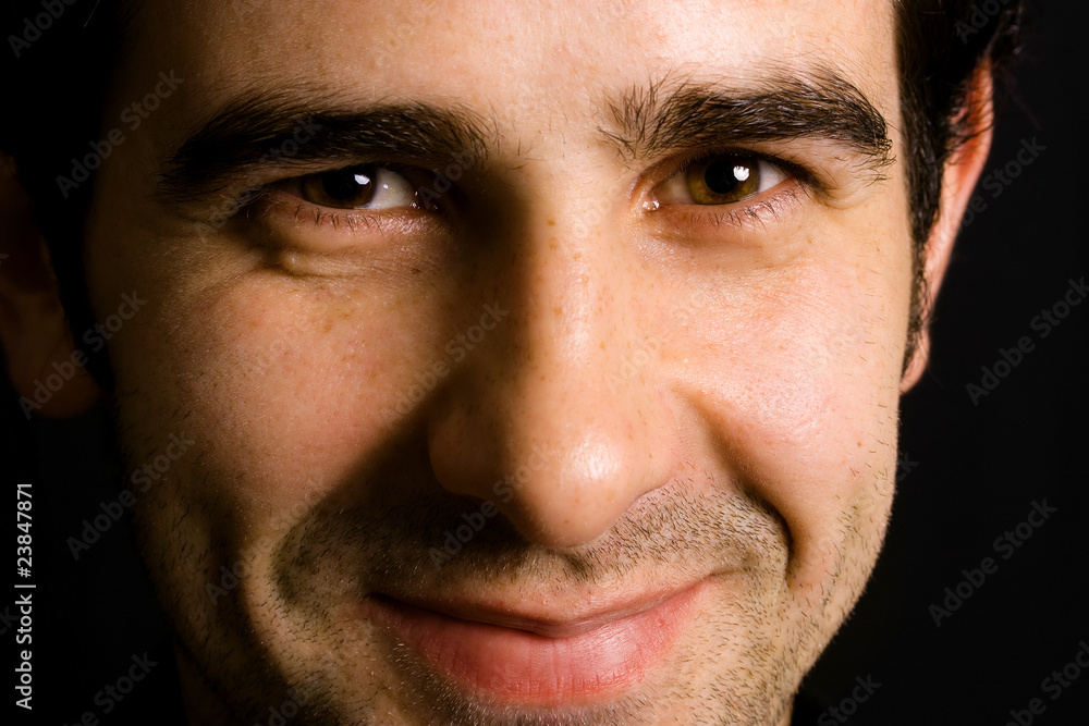 Fototapeta premium Close up portrait of an young attractive man on a black backgrou