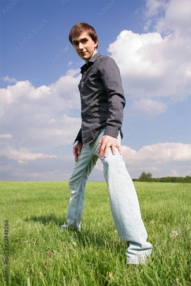 young man in black shirt standing on green lawn at summer time young man in black shirt standing on green lawn at summer time